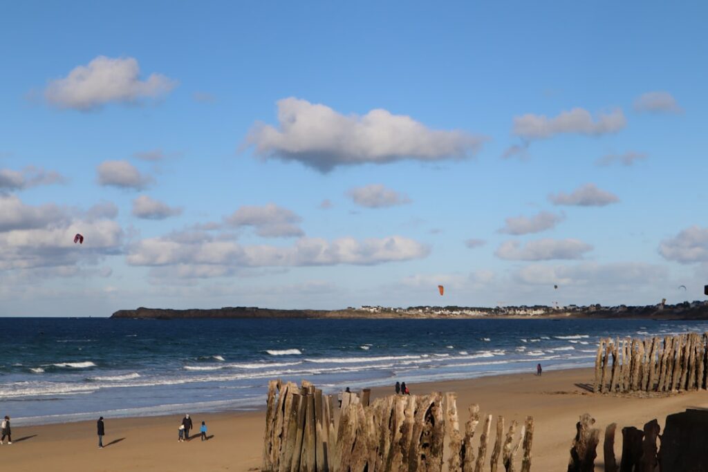 a group of people standing on top of a sandy beach