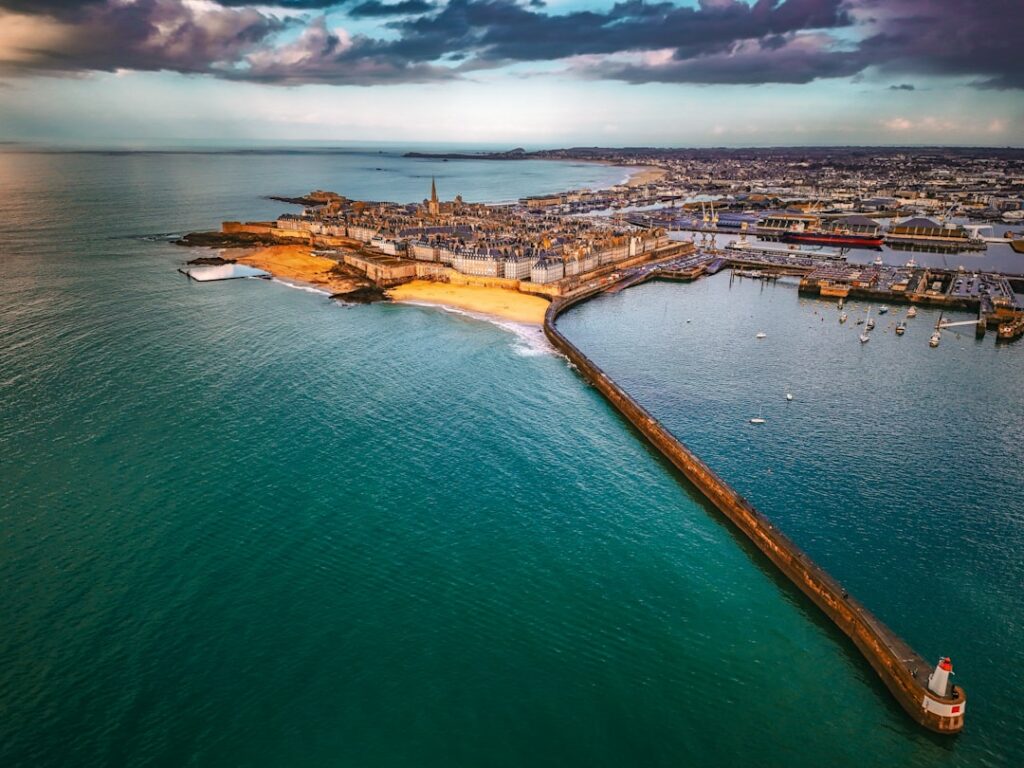 Aerial view of a coastal city with a long pier.